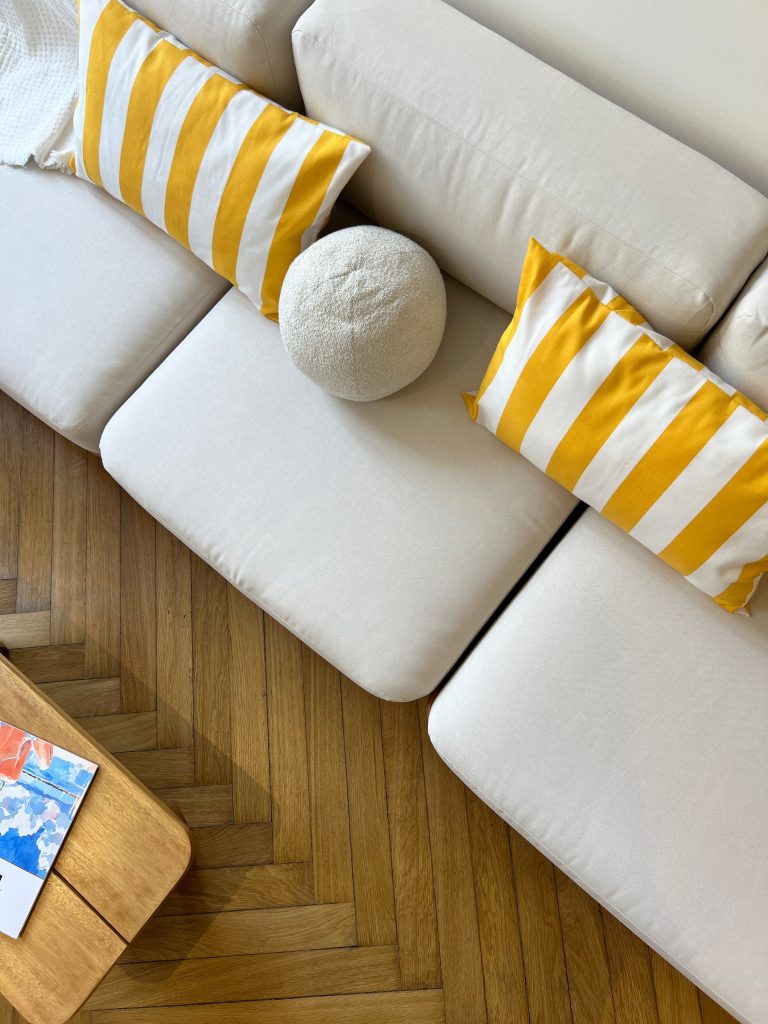 Coussin rayé jaune et canapé beige