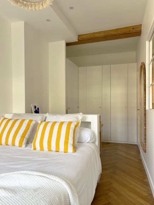 Chambre avec bureau intégré adossé au lit et vue sur les arbres.