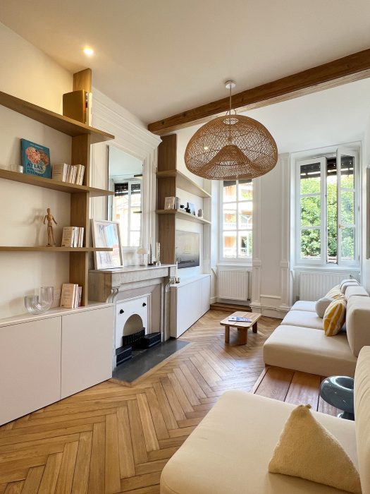 Salon chaleureux baigné de lumière grâce à la verrière.