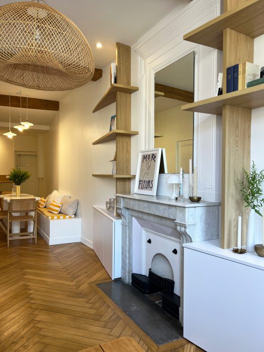 Bibliothèque épurée mettant en valeur livres, objets et écran.