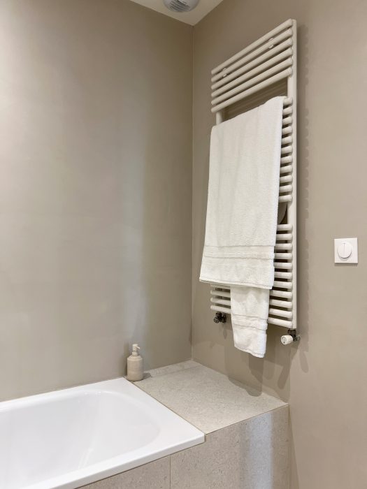 Salle de bain métamorphosée avec béton ciré et carrelage.